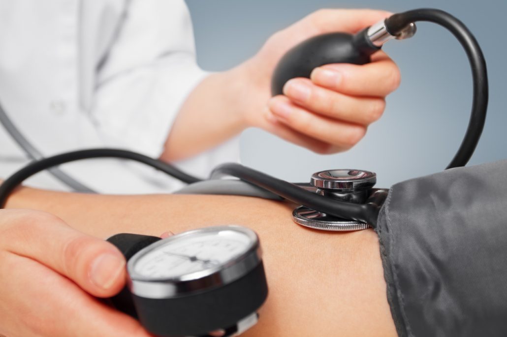 Unrecognizable physician measures blood pressure a patient, close-up