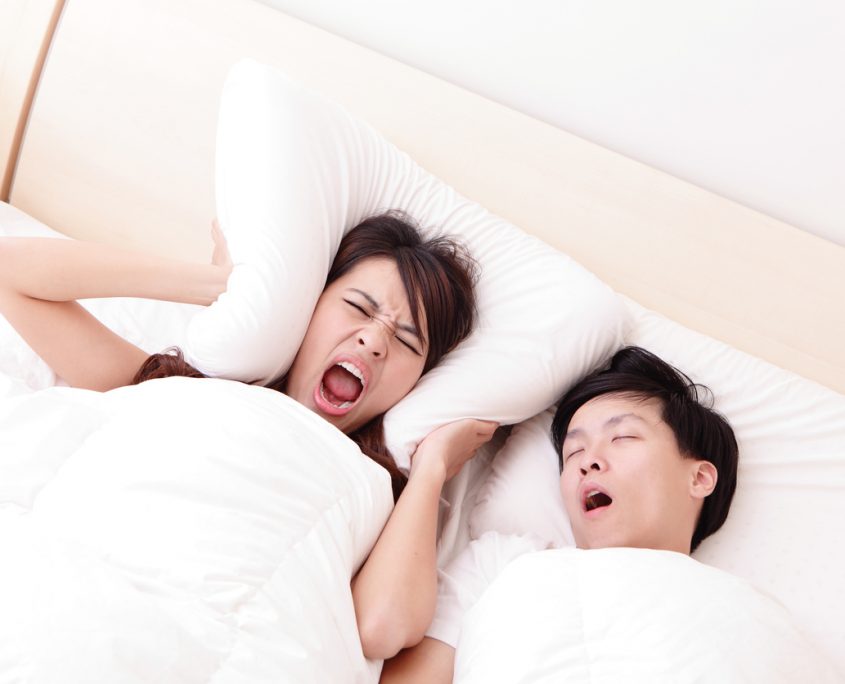 Young woman disturbed by the snores of her husband in the bedroom at home, asian family